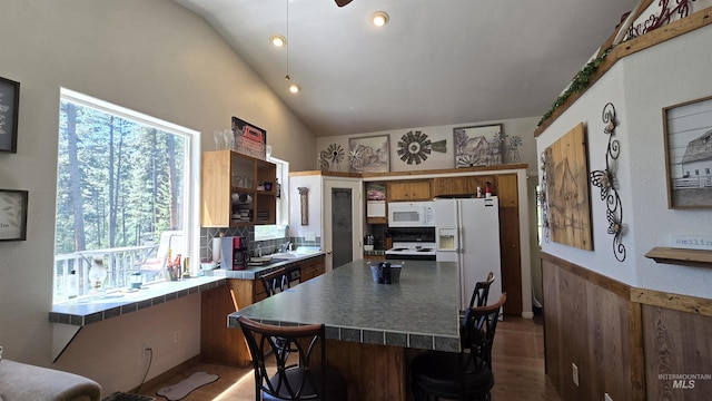 24 Shady Ln, Garden Valley, ID 83622 - kitchen with white appliances, a kitchen breakfast bar, backsplash, a sink, and vaulted ceiling