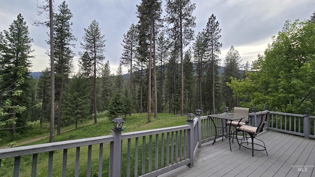 24 Shady Ln, Garden Valley, ID 83622 - deck with outdoor dining space, a yard, and a view of trees