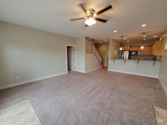 unfurnished living room with light colored carpet and ceiling fan