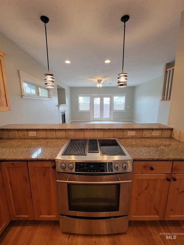 kitchen featuring ceiling fan, hanging light fixtures, stainless steel electric range, and light wood-type flooring