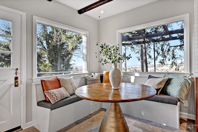 dining room featuring breakfast area and beamed ceiling