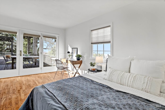 bedroom with access to exterior and wood-type flooring