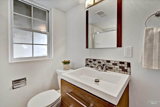 bathroom with vanity, backsplash, and toilet