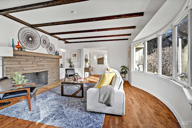 living room featuring hardwood / wood-style flooring, a fireplace, and beamed ceiling