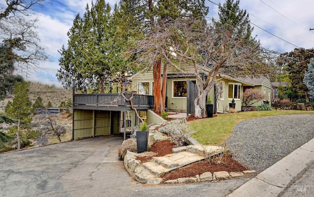 view of front of house featuring a garage, a wooden deck, and a front yard