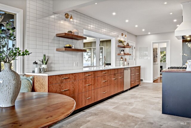 kitchen with backsplash, custom exhaust hood, sink, and dishwasher