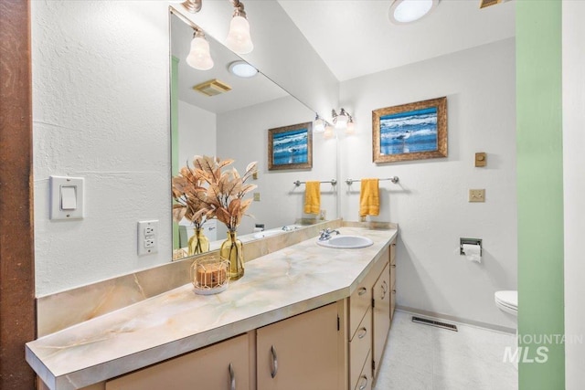 bathroom featuring baseboards, visible vents, vanity, and toilet