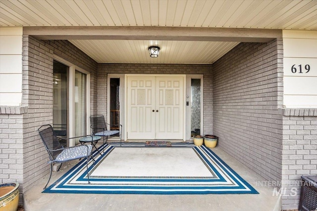 view of exterior entry with brick siding