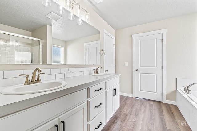 10255 W Gladiola St, Star, ID 83669 - full bath with double vanity, wood finished floors, backsplash, a bath, and a tile shower
