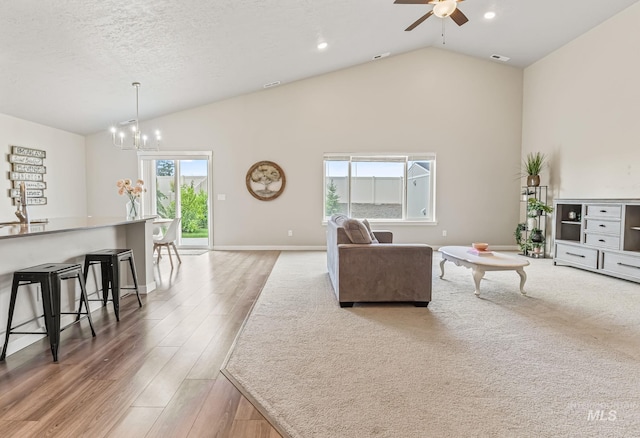 10255 W Gladiola St, Star, ID 83669 - living room featuring a ceiling fan, light wood-style flooring, high vaulted ceiling, a chandelier, and recessed lighting