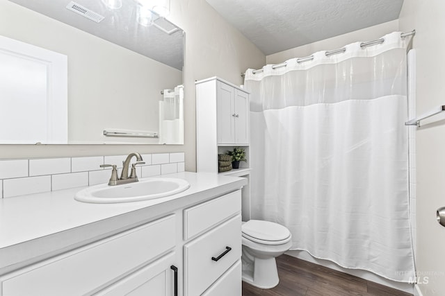 10255 W Gladiola St, Star, ID 83669 - bathroom with vanity, wood finished floors, tasteful backsplash, and a textured ceiling