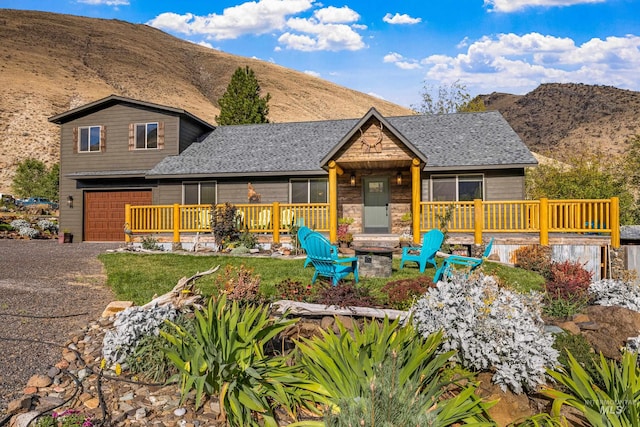 view of front of property featuring covered porch, a mountain view, and a garage