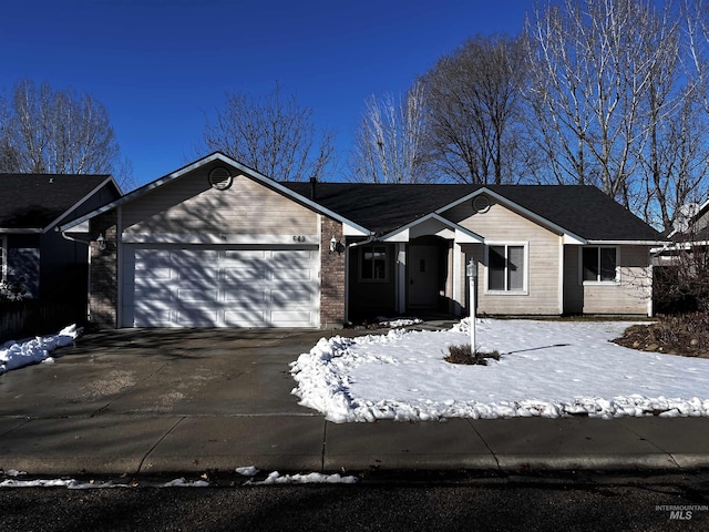 single story home featuring concrete driveway and an attached garage