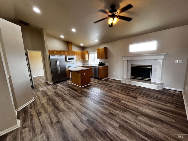 kitchen featuring dark wood finished floors, stainless steel appliances, visible vents, open floor plan, and a kitchen island