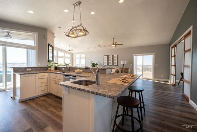 kitchen with open floor plan, stainless steel dishwasher, ceiling fan, and a sink