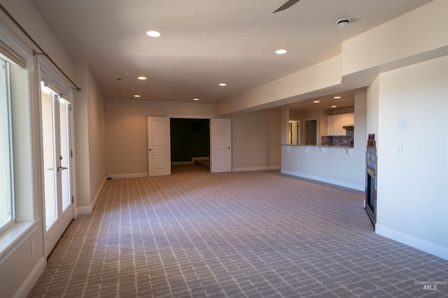 spare room with recessed lighting, baseboards, carpet, and a healthy amount of sunlight