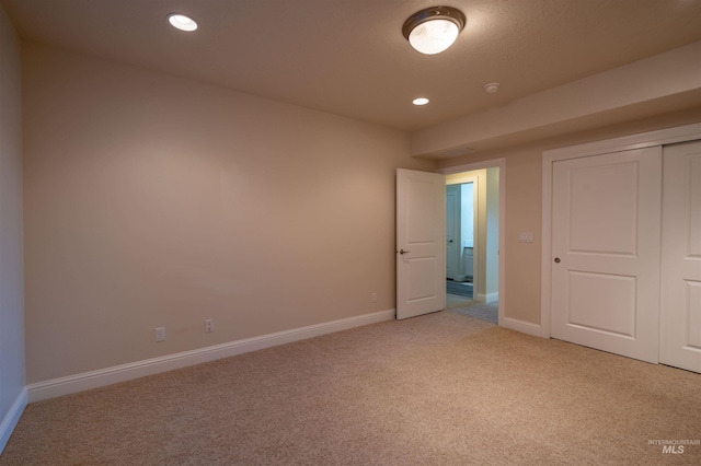 unfurnished bedroom with light carpet, recessed lighting, a closet, and baseboards