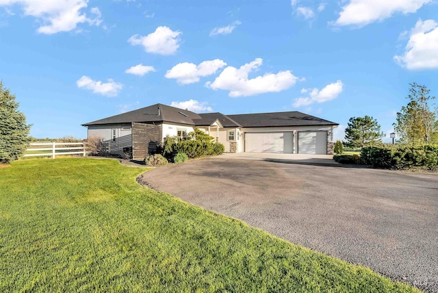 single story home with a front yard, fence, a garage, and aphalt driveway