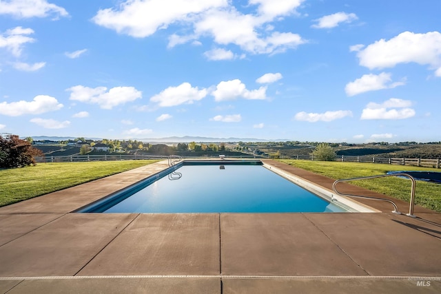 outdoor pool featuring a yard, fence, and a patio area