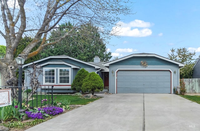 ranch-style house with a garage, fence, driveway, and a chimney