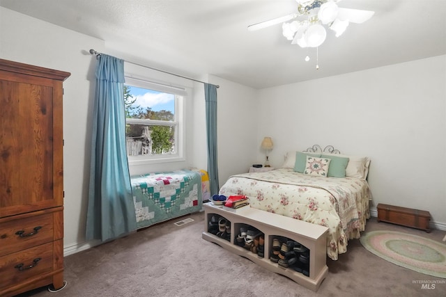 carpeted bedroom featuring a ceiling fan and visible vents