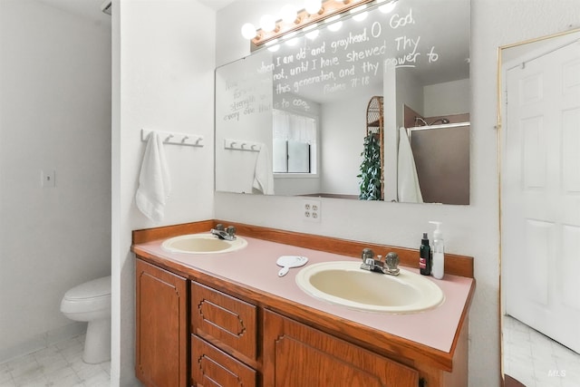 bathroom with double vanity, toilet, a sink, and a stall shower