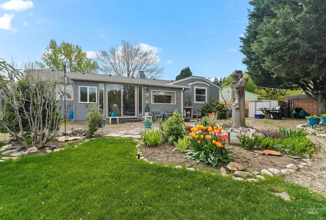 rear view of property featuring a lawn, a patio, and a chimney