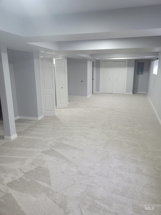 basement with light colored carpet and electric panel