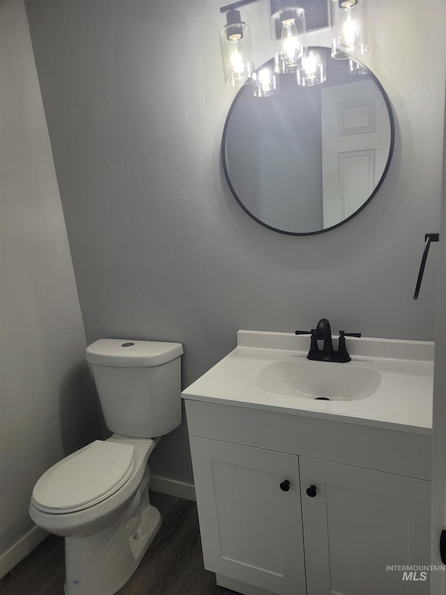 bathroom with hardwood / wood-style flooring, vanity, and toilet