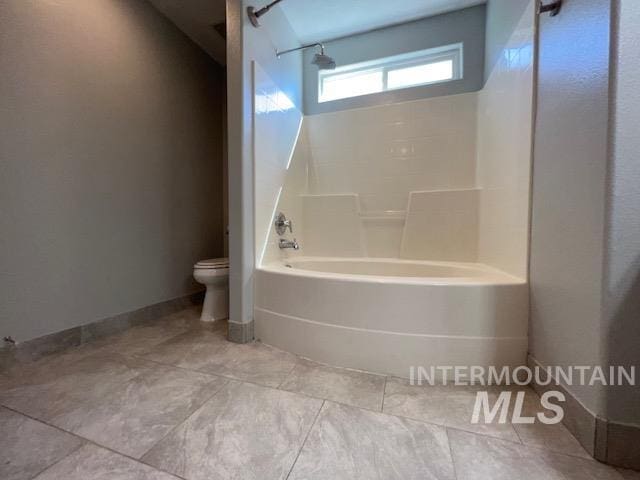 bathroom featuring tile patterned flooring, toilet, and shower / bathtub combination