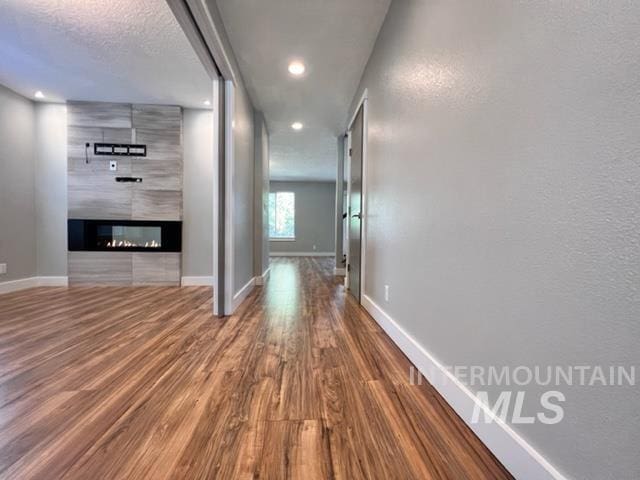 hall with dark hardwood / wood-style flooring and a textured ceiling