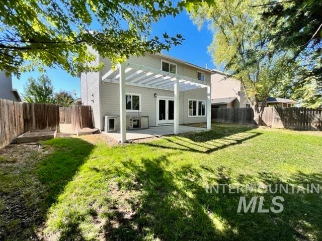 back of property with french doors, a patio, and a lawn