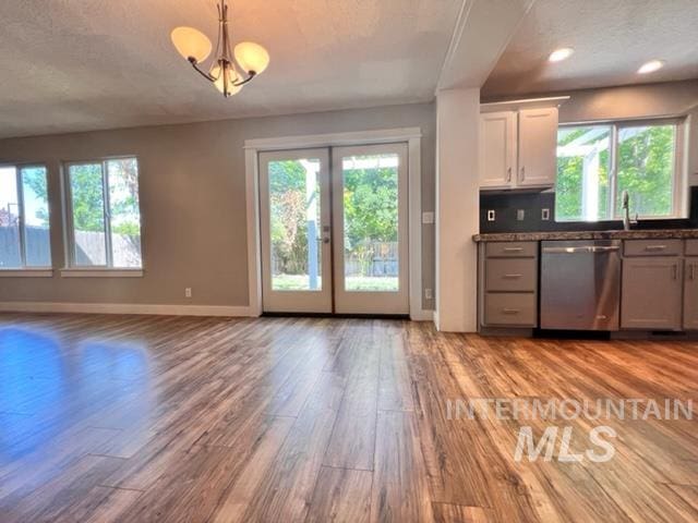 kitchen featuring dishwasher, light hardwood / wood-style floors, plenty of natural light, and white cabinetry