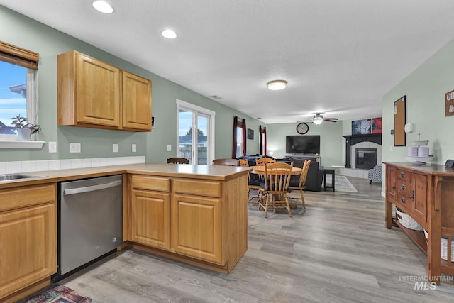 kitchen featuring ceiling fan, dishwasher, kitchen peninsula, and light wood-type flooring