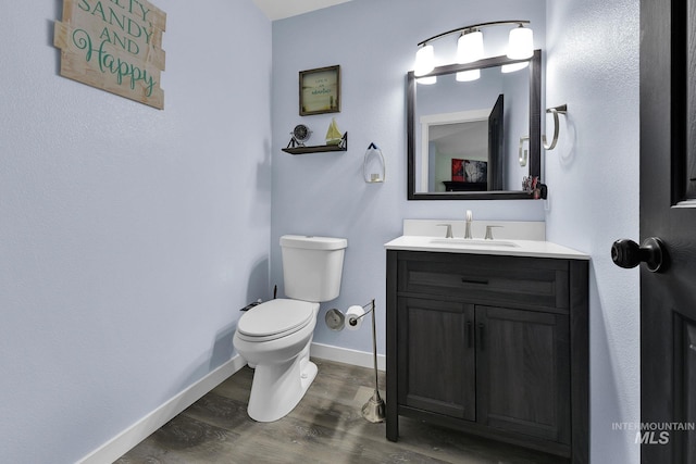 bathroom with vanity, toilet, and hardwood / wood-style floors