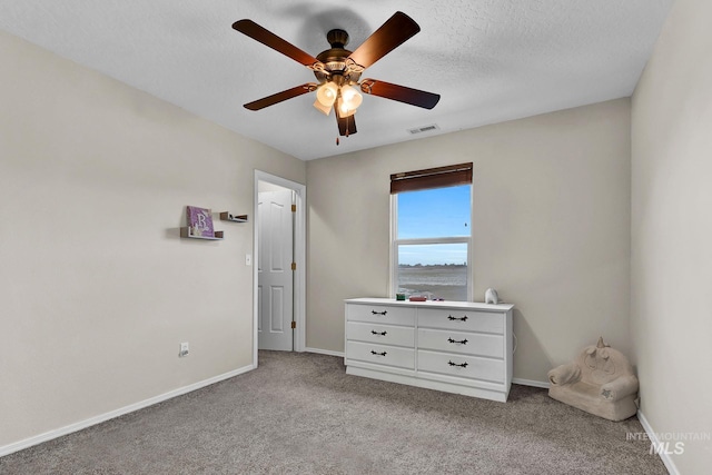 unfurnished bedroom with light carpet, ceiling fan, and a textured ceiling