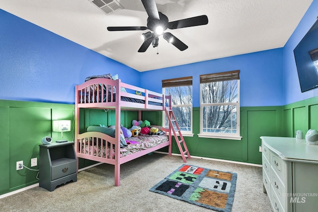 bedroom with a textured ceiling, light colored carpet, and ceiling fan