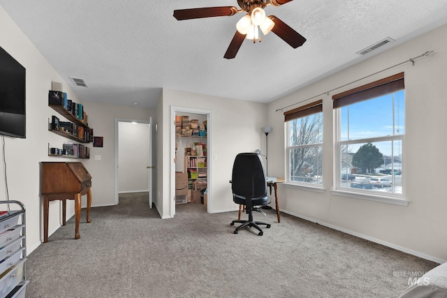 office area with a textured ceiling and carpet flooring