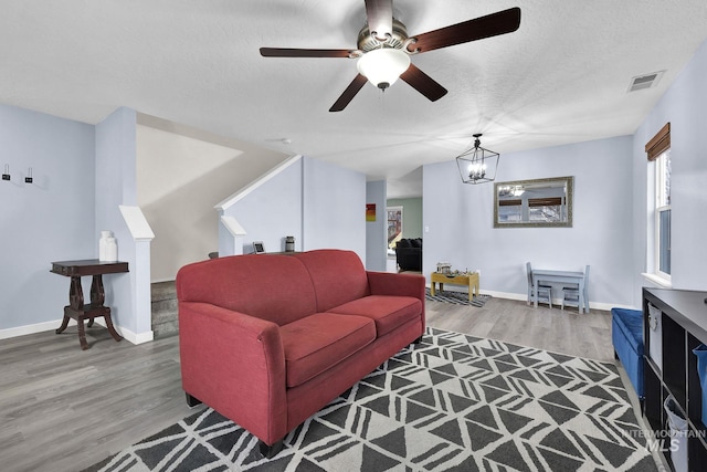 living room with hardwood / wood-style floors, a notable chandelier, and a textured ceiling