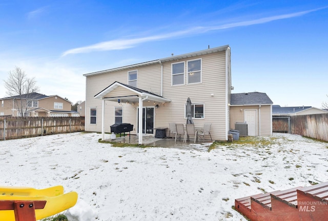 snow covered house featuring a patio area