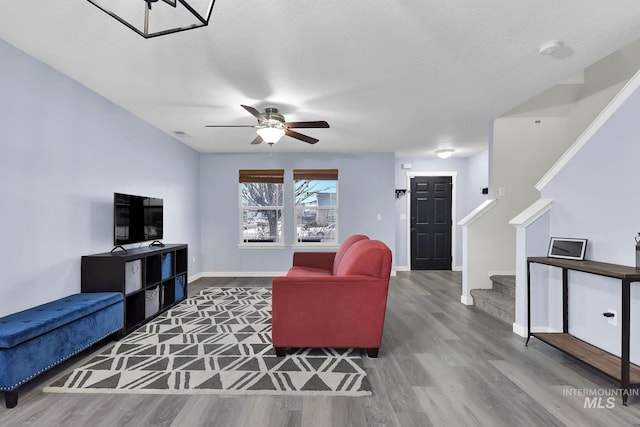 living room with hardwood / wood-style floors, a textured ceiling, and ceiling fan