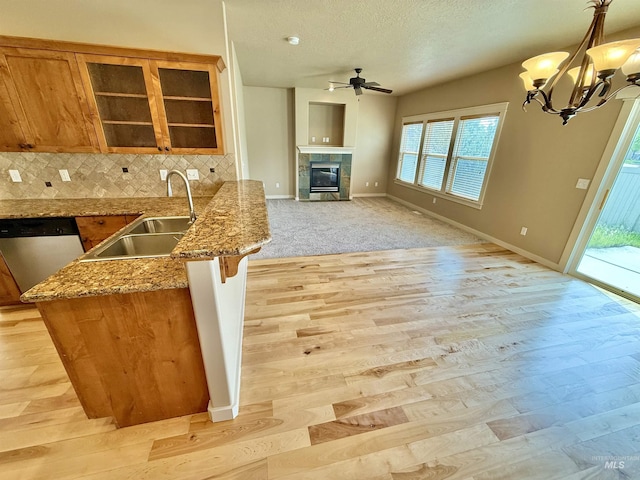 1241 W Ann Taylor St, Meridian, ID 83646 - kitchen featuring a sink, dishwasher, brown cabinetry, ceiling fan, and a fireplace