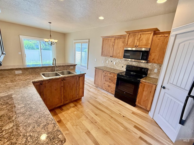 1241 W Ann Taylor St, Meridian, ID 83646 - kitchen featuring stainless steel microwave, black electric range oven, a sink, a textured ceiling, and light wood-style floors