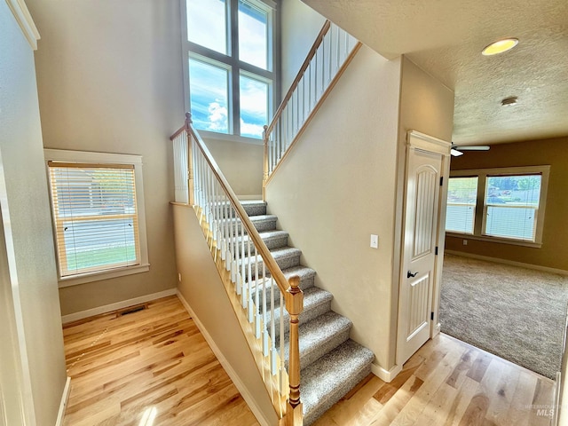 1241 W Ann Taylor St, Meridian, ID 83646 - stairs with baseboards, wood finished floors, healthy amount of natural light, a textured ceiling, and recessed lighting