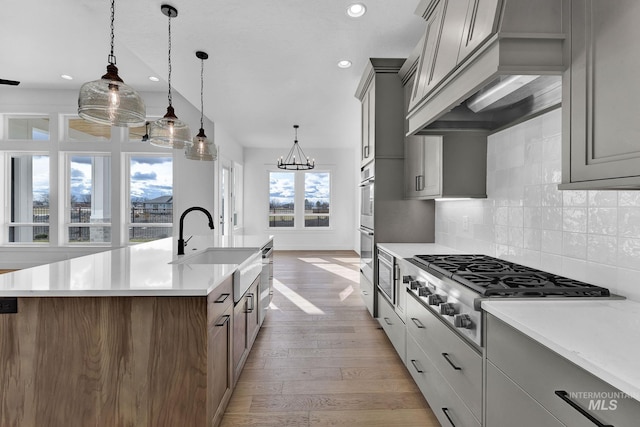 11321 S Yeoman St, Kuna, ID 83634 - kitchen with stainless steel appliances, a sink, light wood-type flooring, an island with sink, and recessed lighting