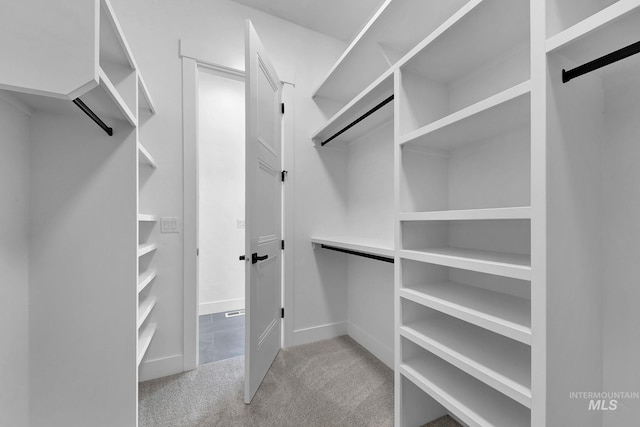 walk in closet featuring light carpet