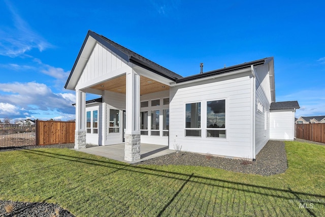 back of property featuring a patio area and a yard