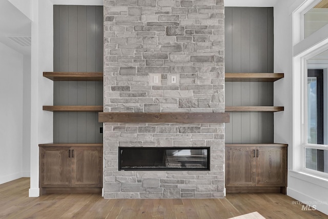 unfurnished living room with a fireplace and light wood-type flooring