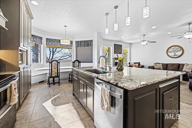 kitchen with appliances with stainless steel finishes, open floor plan, a healthy amount of sunlight, and a sink