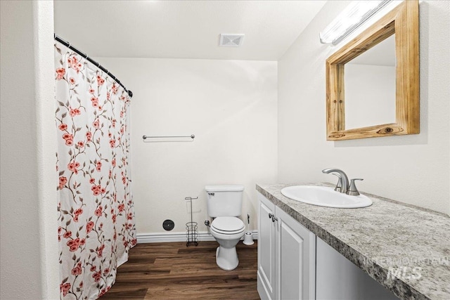 full bath with toilet, wood finished floors, vanity, visible vents, and baseboards